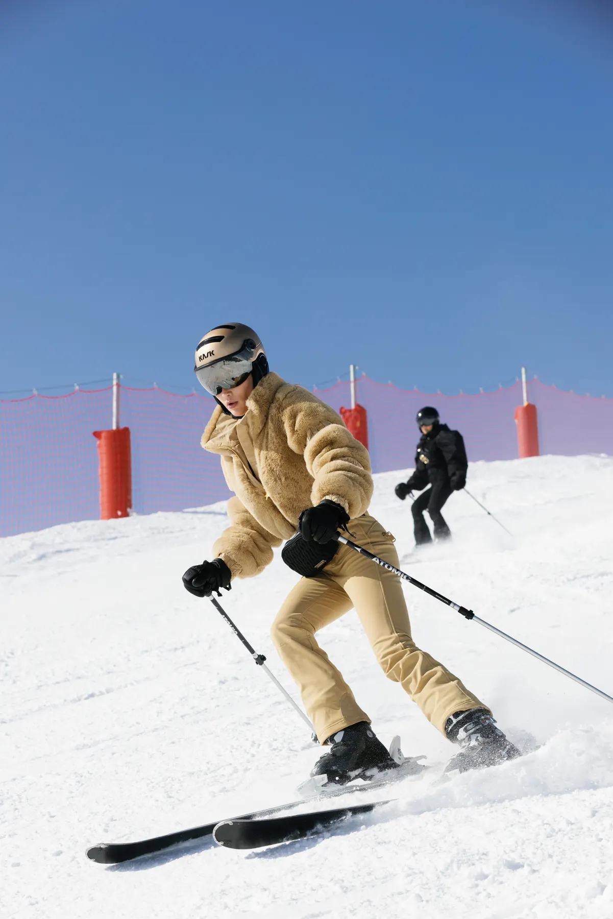 Woman skiing in a gold Goldbergh outfit on the slopes of Courchevel.