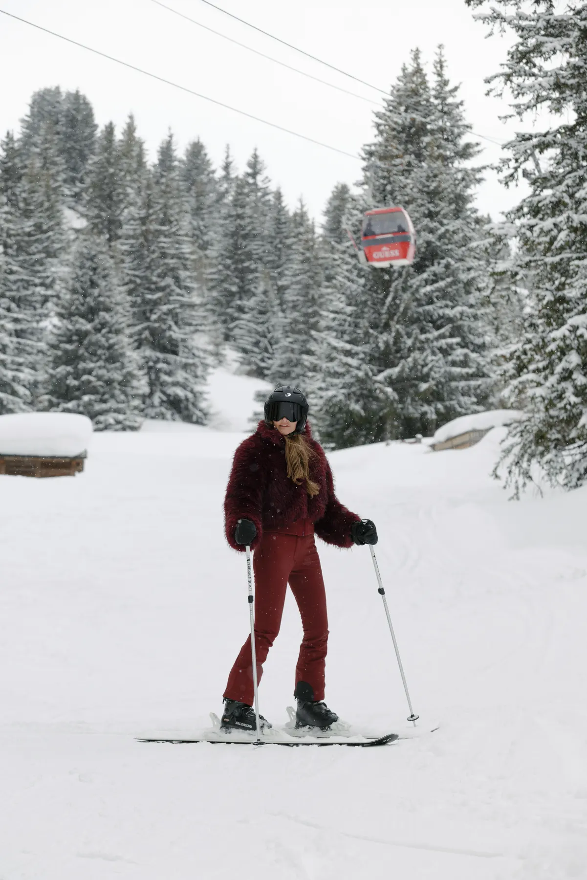 Woman wearing a red Goldbergh ski outfit posing on the slopes in Courchevel.