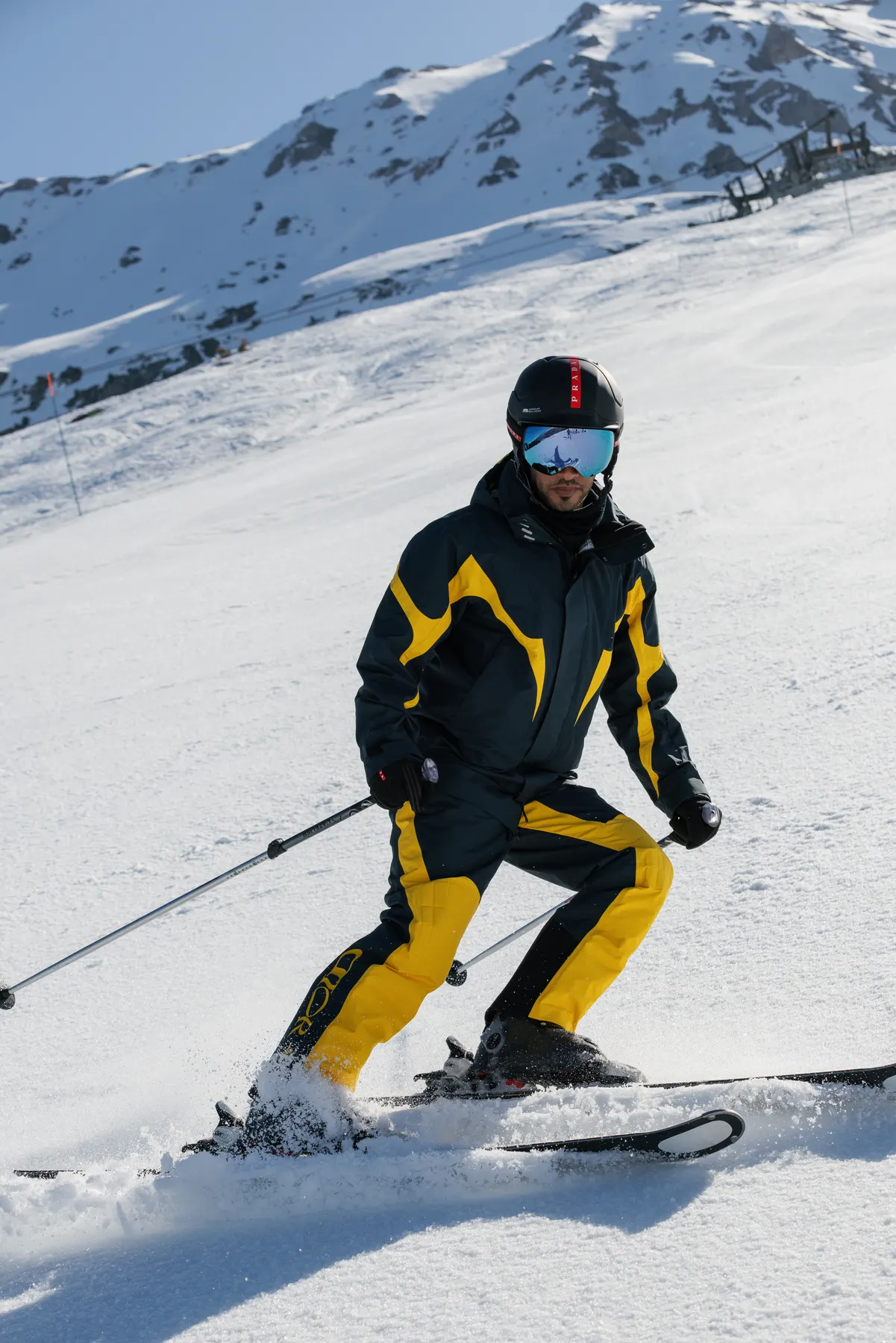 Skier wearing a black and yellow Dior ski suit on the slopes in Courchevel.