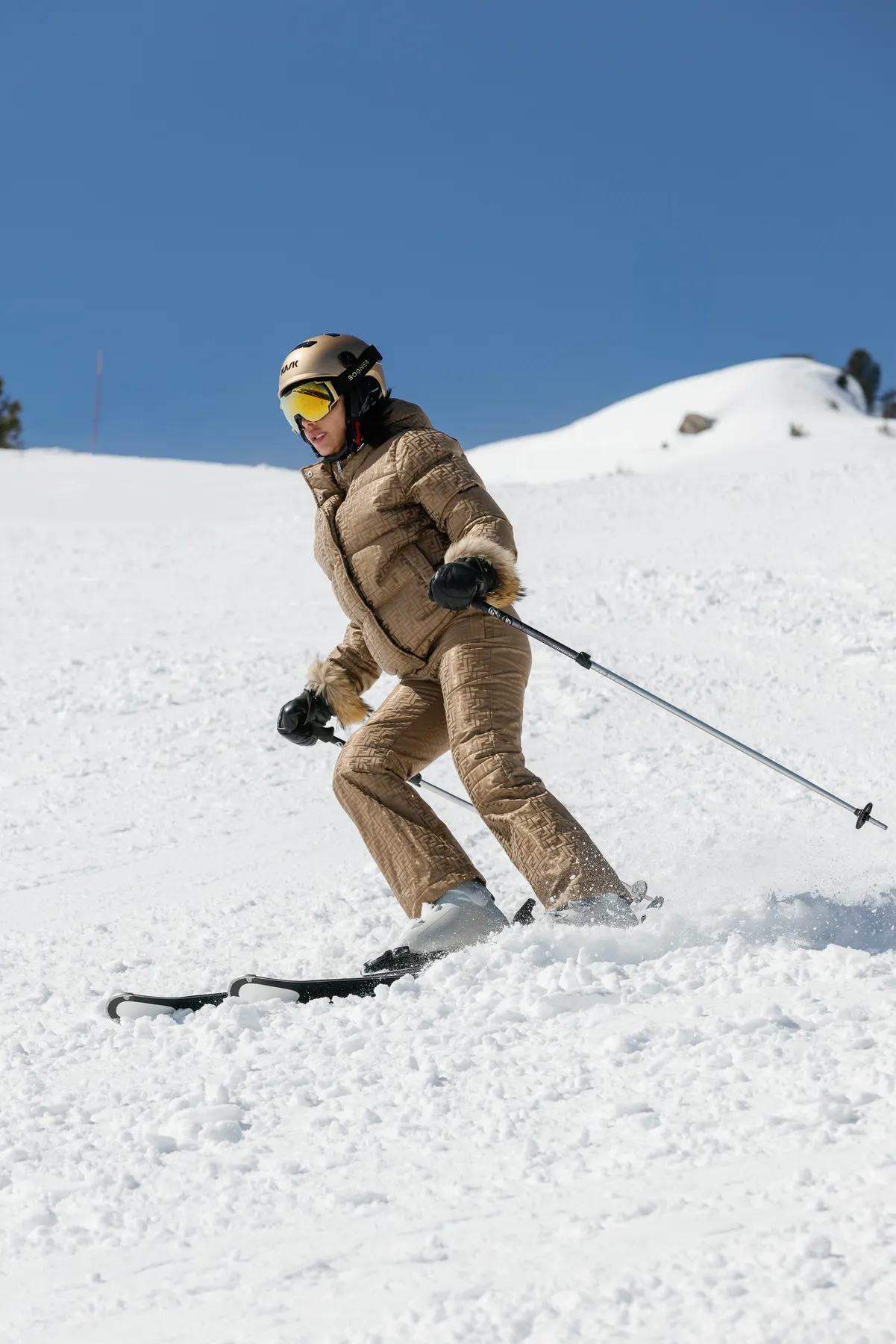 Woman wearing Fendi ski wear skiing during a luxury ski holiday in Courchevel.